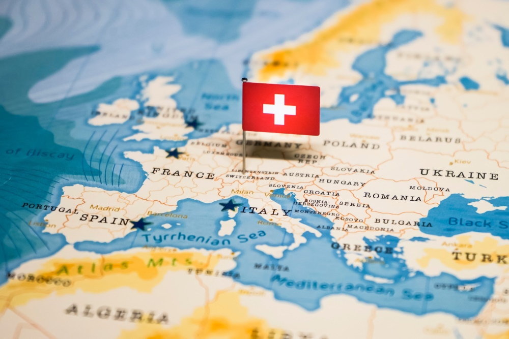 Beitragsbild mit einer Europkarte die eine Stecknadel mit der Landesflagge der Schweiz enthält. Bildnachweis shutterstock 1331085791